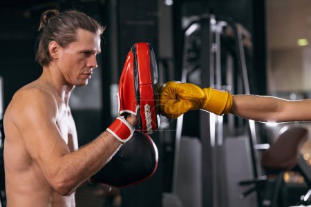 Photo for Boxing coach training punch kickboxing with athlete focus trainer in fitness gym for muscle and healthy sport - Royalty Free Image