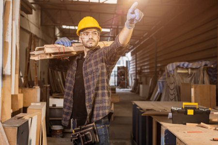 Photo for Portrait smart builder wood male furniture maker, sawmill worker professional standing strong and confident carrying wooden planks - Royalty Free Image