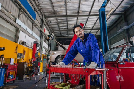 Photo for Portrait Asian Japanese male mechanic worker portrait in auto service workshop car maintenance center replace fix auto engine part - Royalty Free Image