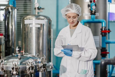 Professionelle QC Mitarbeiter arbeiten in der Wissenschaft medizinische Labor Getränke Getränke Fabrik überprüfen Rekord Filter Tank glücklich arbeiten