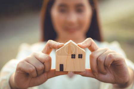 Photo for People hand holding miniature wooden house model for banking housing mortgage real estate rent lease home family concept - Royalty Free Image