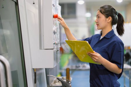 Las mujeres del ingeniero controlan operan la máquina industrial del CNC en taller de la producción del metal. Asiática joven mujer industria trabajador.