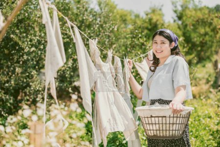 Rural farm girl folk women maid housewife drying clothes outdoors vintage retro style countryside people.