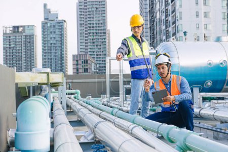 engineer teamwork technician workers service hotel boiler tank hot water supply pipe system. team working safety checking maintenance pipeline heating water delivery line at roof top outdoor.