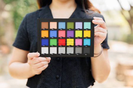 Modèle de photographie tenant un tableau de contrôle des couleurs ou un nuancier pour calibrer des photos ou des vidéos en couleurs précises