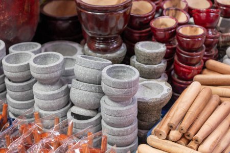 Hand pounded mortars and pestles, stone and wood type, traditional kitchen utensils sale in Thai handcraft market