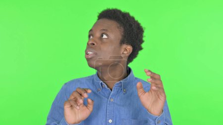 Photo for Casual African Man Feeling Scared, Frightened on Green Background - Royalty Free Image