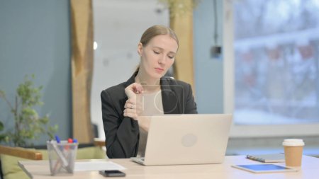 Téléchargez les photos : Young Businesswoman having Wrist Pain while using Laptop - en image libre de droit