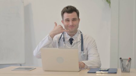 Photo for Call Me Gesture by Young Doctor at Work - Royalty Free Image