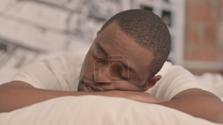 Foto de Hombre africano cansado durmiendo en la cama con el estómago - Imagen libre de derechos