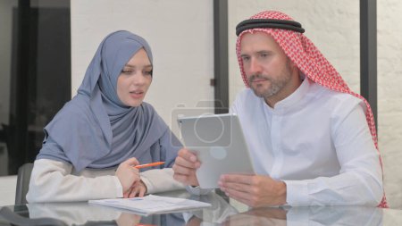 Empresario árabe hablando con mujer musulmana en el cargo