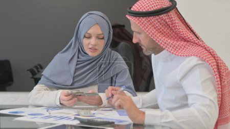 Jóvenes árabes haciendo cálculos financieros