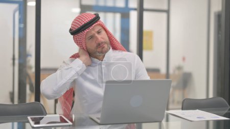 Hombre árabe con dolor de cuello en el cargo