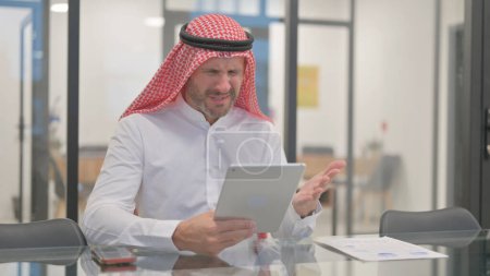 Arab Man Reacting to Money Loss on Tablet