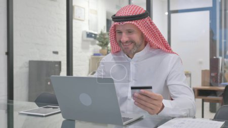Excited Middle Aged Muslim Man Enjoying Online Shopping