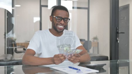 Jeune homme africain Compter de l'argent en fonction