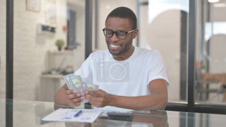 L'homme afro-américain compte l'argent au bureau