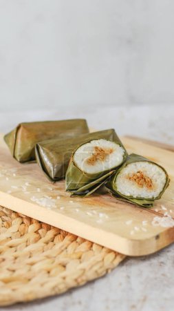 Téléchargez les photos : A close up of Lontong. Traditional food from Indonesia originating from rice filled with vegetables or meat and wrapped in banana leaves. Indonesian traditional food photo concept. - en image libre de droit