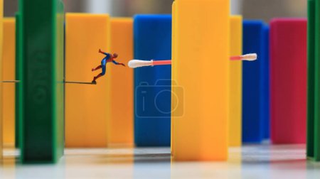 Téléchargez les photos : A miniature human figure with the power of a spider jumping over a colored block toy. their concept of reimagining superheroes. - en image libre de droit