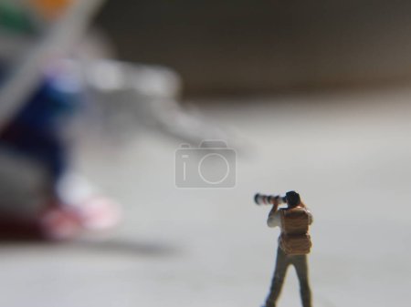 Photo for Miniature figure of a photographer taking a photo of a robot. - Royalty Free Image