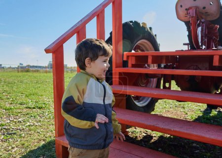 Foto de Joven entusiasmado con la exposición de tractores en la feria - Imagen libre de derechos