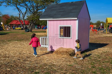 Foto de Niños corriendo y coloreando en una casa de tiza en la feria de la granja en Halloween - Imagen libre de derechos