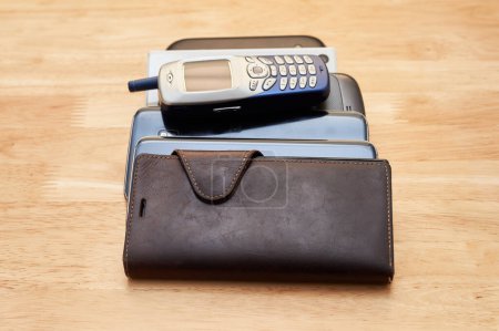 Foto de Un montón de viejos teléfonos celulares usados de diferentes décadas amontonados sobre la mesa - Imagen libre de derechos