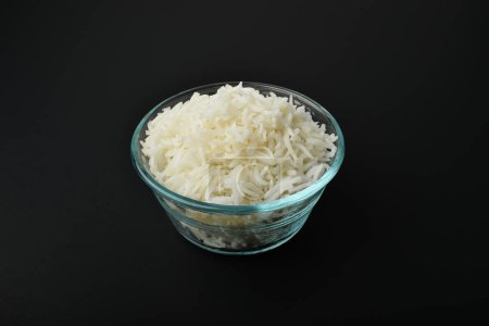 a small serving of basmati rice in a glass bowl on a black background
