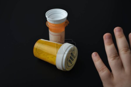 child trying to grab a child proof pill bottle
