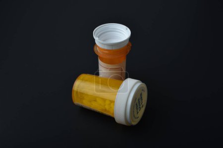 old child proof pill bottles on a black background