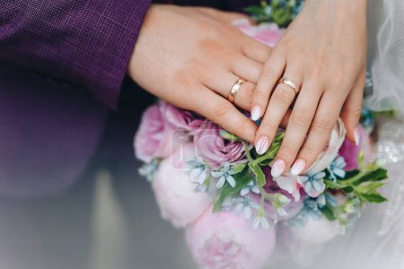 Photo for Hands with wedding rings. hands of the bride and groom with wedding rings and bridal bouquet. the groom gently holds the brides hand . High quality photo - Royalty Free Image