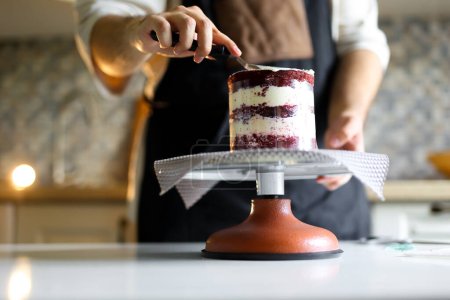 Téléchargez les photos : Un pâtissier professionnel décore un gâteau pour une occasion spéciale Gâteau luxueux avec un décor unique créé par un pâtissier expérimenté. Photo de haute qualité - en image libre de droit