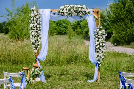 Téléchargez les photos : Élégante belle arche de mariage décorée de délicates fleurs blanches. Photo de haute qualité - en image libre de droit