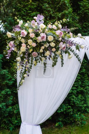 Photo for Wedding rectangular arch at an outdoor ceremony with pink and white roses against a background of greenery. High quality photo - Royalty Free Image
