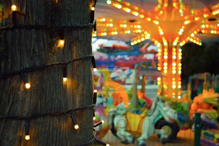 Multi-colored lights in an amusement park. Carousels. Recreation and entertainment.
