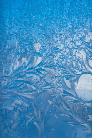 Frost on the glass. Beautiful frosty patterns. Winter background. Ice texture.