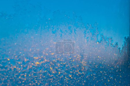 Frost on the glass. Beautiful frosty patterns. Winter background. Ice texture.