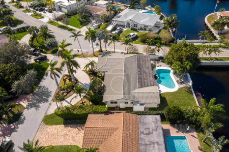 Photo for Aerial image of a residential neighborhood, houses with swimming pools, cars, boats, bridges, tropical plants, palms in pompano beach FL USA Miami beach drone view - Royalty Free Image