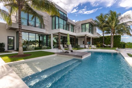 Foto de Florida, USA. Modern building with swimming pool, trees, chairs. Urban landscape with blue reflecting pool, city architecture, and scenic environment. - Imagen libre de derechos