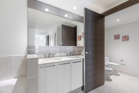 Fotoshooting Footage in Florida, USA. Sauberes, modernes Badezimmer mit erfrischender Dusche, reflektierendem Spiegel, Badewanne und eleganten Fliesen.