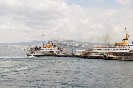 Barcos cerca de muelle con islas princesa y Estambul en el fondo en Turquía 