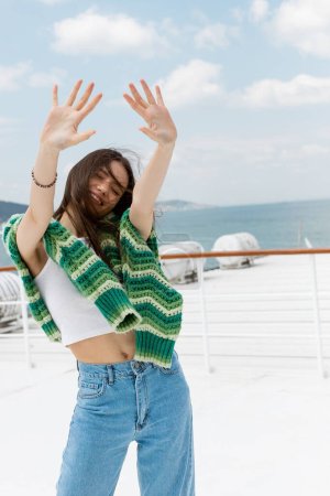 Carefree traveler with sweater outstretching hands during cruise in Turkey 