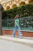 Brunette woman in sweater and jeans walking on street in Istanbul t-shirt #649766054