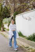 Trendy young woman in top and shirt walking on urban street in Istanbul t-shirt #649767858
