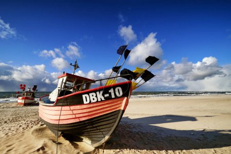 Foto de DABKI, POLONIA: Cortadores o barcos de pesca en la playa del Báltico. Debido a las restricciones de pesca, hay cada vez menos de ellos. - Imagen libre de derechos