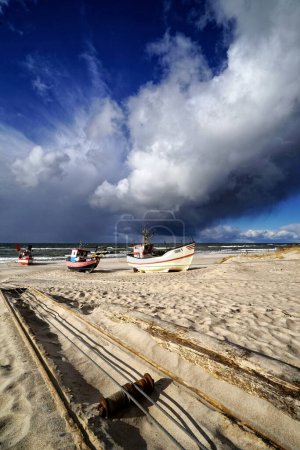 Foto de DABKI, POLONIA: Cortadores o barcos de pesca en la playa del Báltico. Debido a las restricciones de pesca, hay cada vez menos de ellos. - Imagen libre de derechos