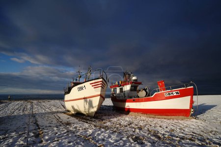 Foto de DABKI, POLONIA - CIRCA DICIEMBRE 2022: Cortadores o barcos de pesca en la playa del Báltico. Debido a las restricciones de pesca, hay cada vez menos de ellos. - Imagen libre de derechos