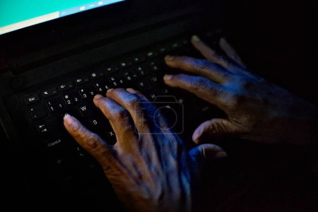Hände tippen auf einer Computertastatur mit dem Ziel, Fake News im Internet zu verbreiten. Image mit journalistischem Konzept