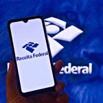 Rio de Janeiro, Brazil. 02, 16, 2024. Brazilian Federal Revenue logo on a cell phone screen in front of a computer screen background