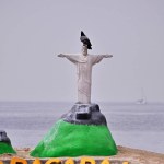 Handcrafted statue of Christ the Redeemer made from beach sand. With a pigeon on top of the sand statue. Problem concept in Rio de Janeiro.